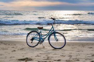 bike resting on the sand by the waves