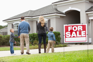 Family in front of a house for sale